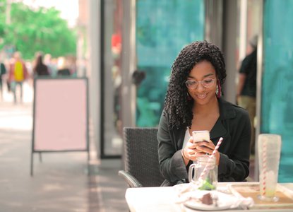 smiling-woman-using-phone-coffee-shop.jpg