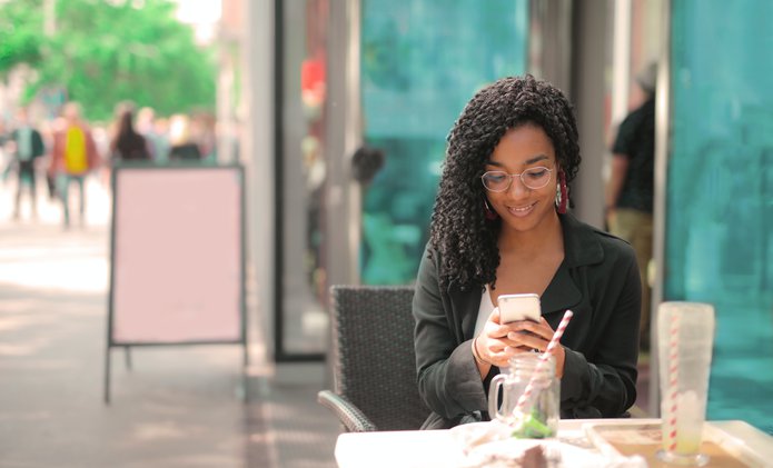 smiling-woman-using-phone-coffee-shop.jpg