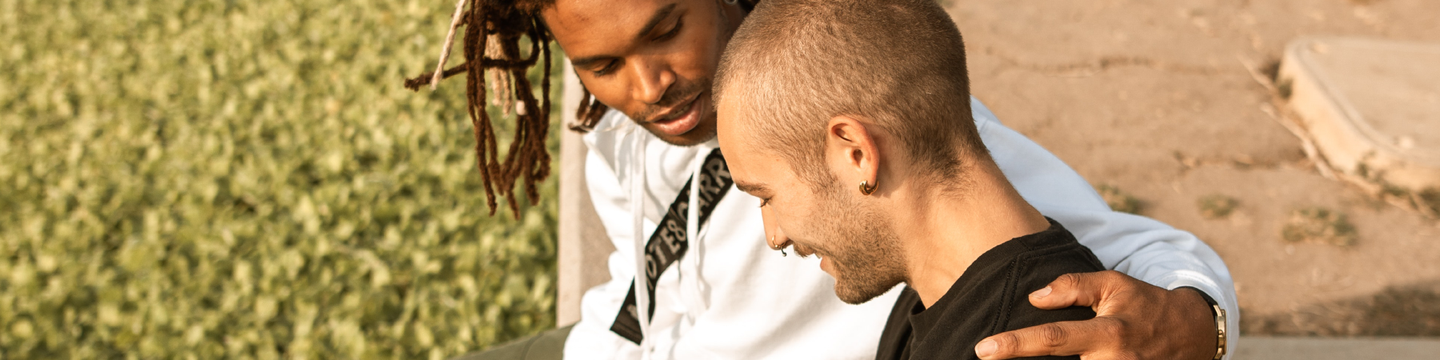 Two young men chatting in a park.png