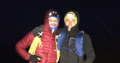 Ashley and Owain in outdoor gear with head torches at night.png